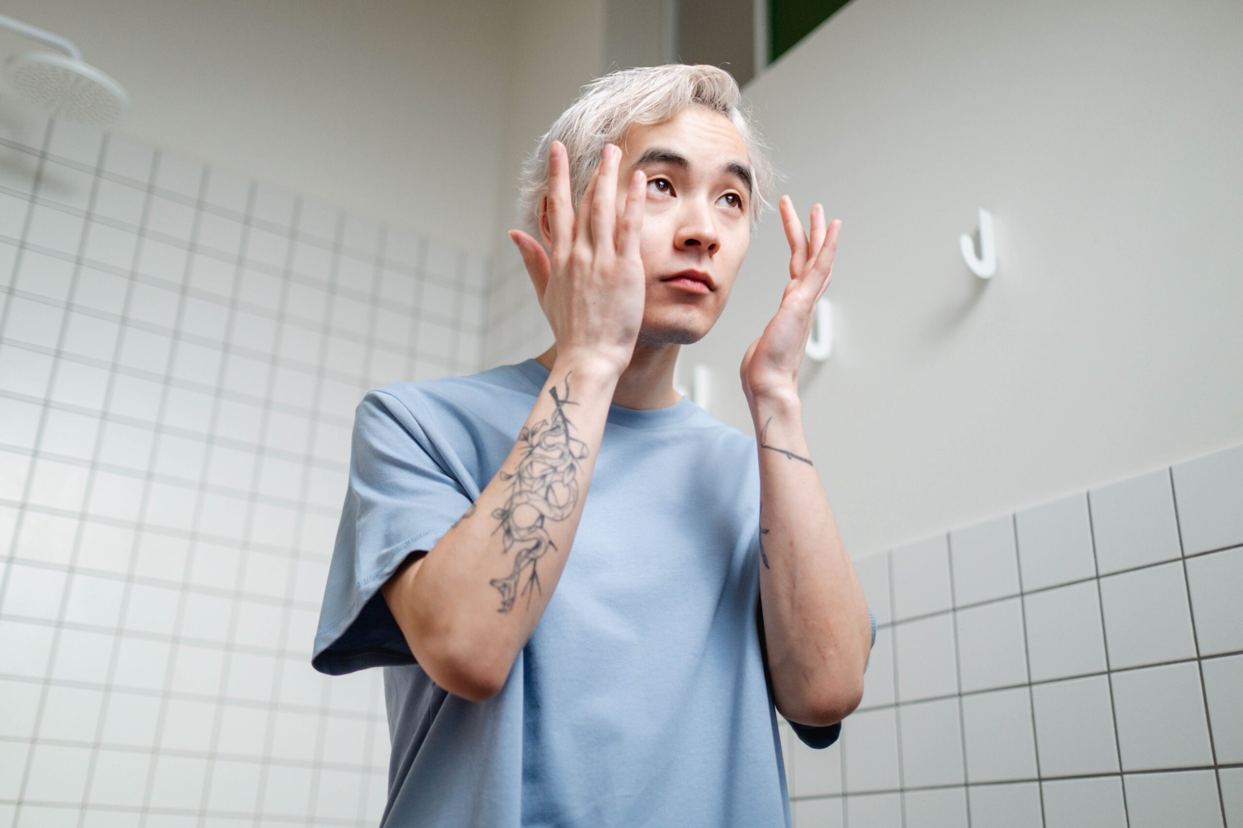 鏡の前で身支度をする男性（記事1ヒーロー画像）